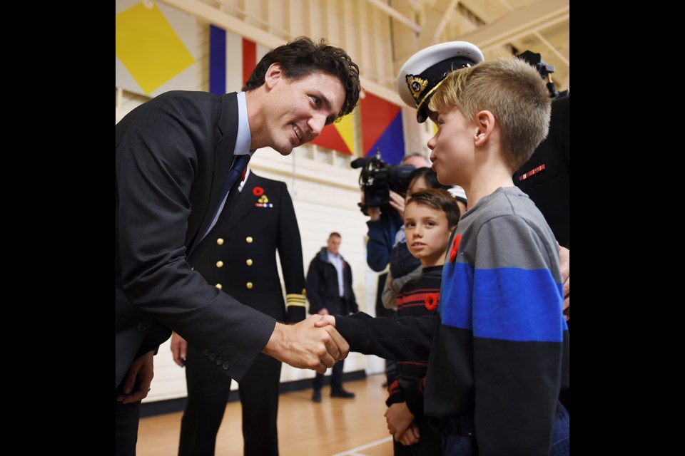 Prime Minister Justin Trudeau is greeted by the Commanding officer of the HMCS Discovery, Bryan Price, along with his two sons Scott (9) and Colin (11). Trudeau shook Colin's hand. The Prime Minister made an announcement with the Minister of Transport, Marc Garneau, Nov. 7 at HMCS Discovery. Photo Dan Toulgoet