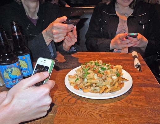 鶹ýӳfoodies take pictures of the chicken and waffle poutine offered at 131 Water Kitchen & Bar as part of the second annual 鶹ýӳFoodster Poutine Challenge.