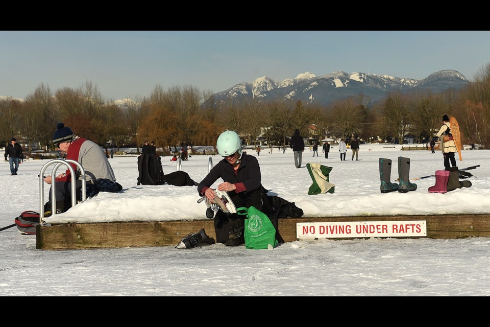 To remover her ice skates, Lisa Patterson sits on a dock that is usually floating on Trout Lake Jan. 5, 2017. Photo Dan Toulgoet