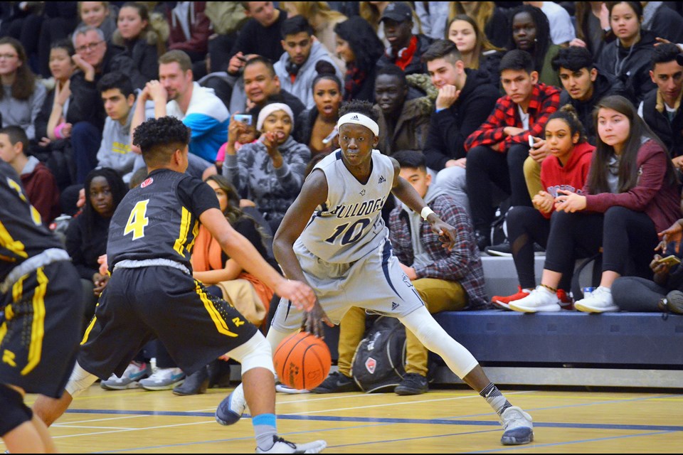 The Byrne Creek Bulldogs’ Bithow Wan, right, prepares to take on Burnaby South Rebels’ defender Yaphet Soloman during Wednesay’s senior boys showdown at Byrne Creek. The Bulldogs grabbed an early lead and made it stick, prevailing 79-65 to remain undefeated in Burnaby-New West senior boys basketball action.