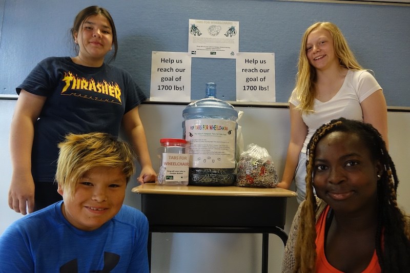 Juniper School Grade 7 students Winter Ross (back left), Madison Jackson (back right), Ethan Dumas (front left) and Debby Olubowe (front right) with the some of the 40 pounds of aluminum beverage can tabs that a tabs for wheelchairs program headquartered at their school has collected already. The goal is to collect 1,700 pounds by next May for the purchase of a wheelchair.