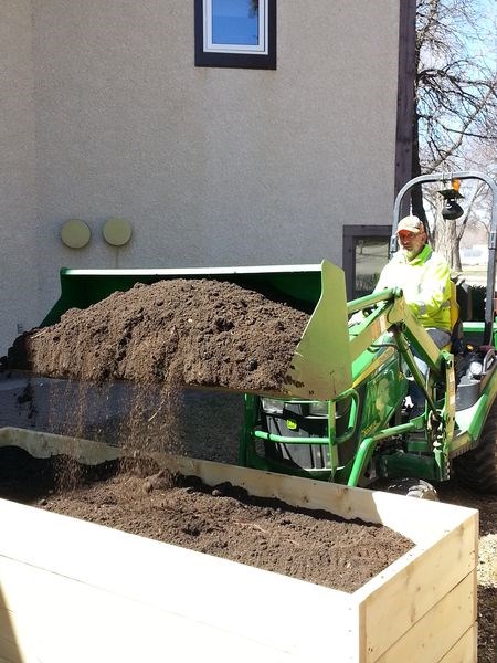 John Fernuik used his tractor and front-end loader last week to haul and deposit soil into three newly-constructed planters located on the grounds at Davies Tower, a seniors’ apartment complex located on Queen Elizabeth Boulevard in Kamsack. The planters will be used for growing vegetables by tenants of the building.