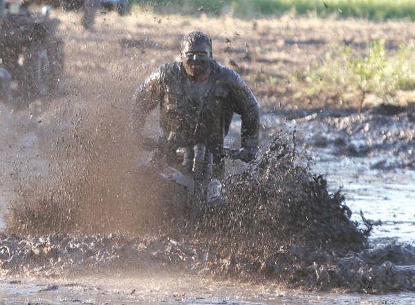 Brock Maksymiw makes his way through the mudhole on Saturday on his four wheeler.