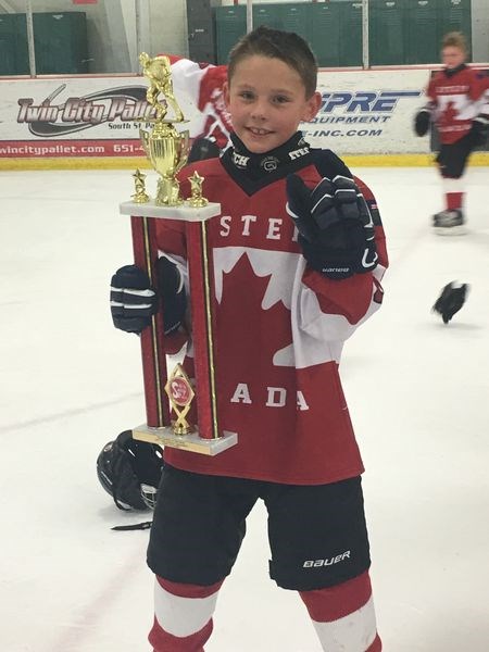 Trae Peterson proudly displayed the gold cup that his team from Canada won in a hockey tournament in Minneapolis.