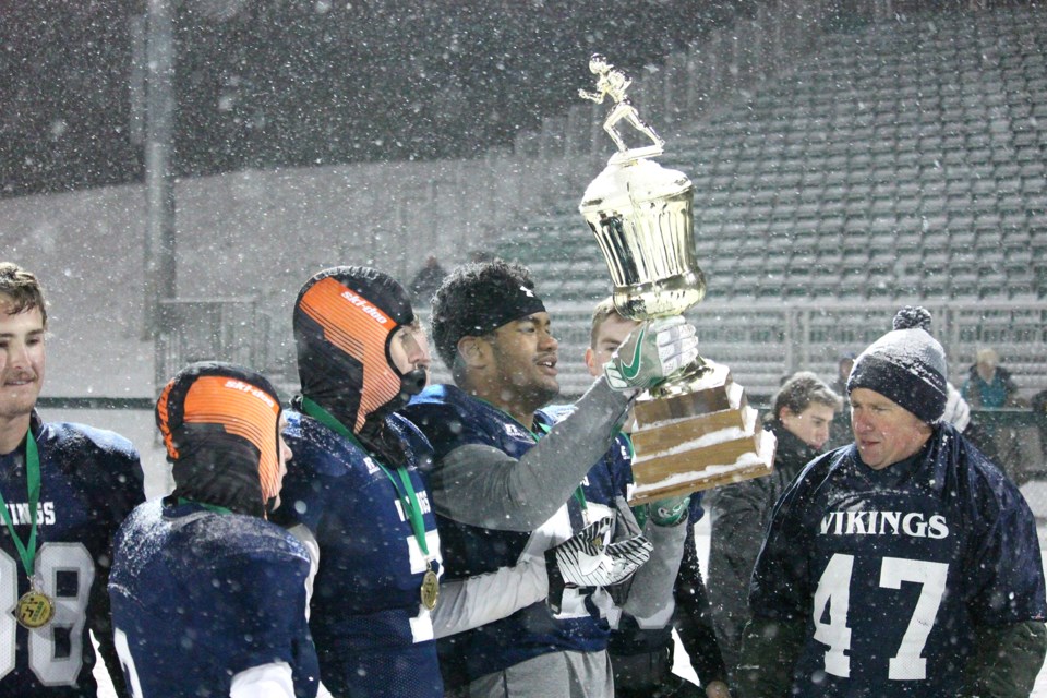 Apete Tuiloma hoisted the SSSAD 3A football championship trophy after the North Battleford Comprehensive High School Vikings won their first league title Friday night in Saskatoon. Photo by Lucas Punkari