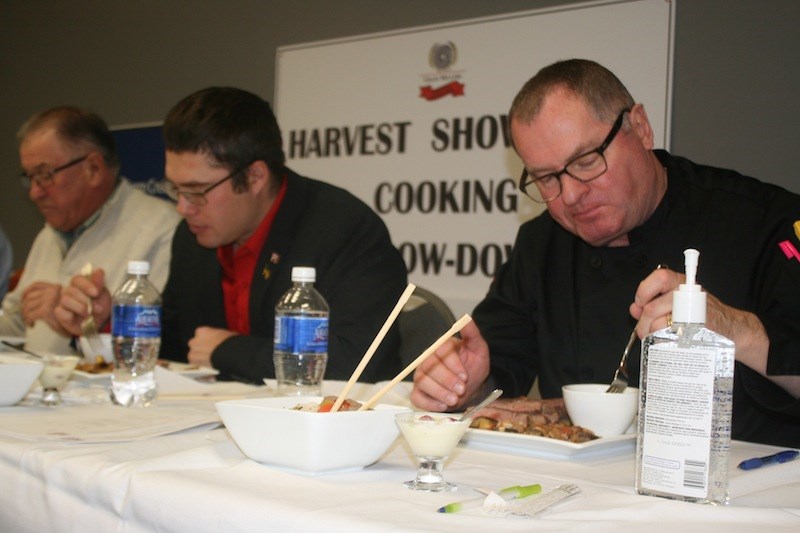 John Penner (right) samples food with his fellow judges