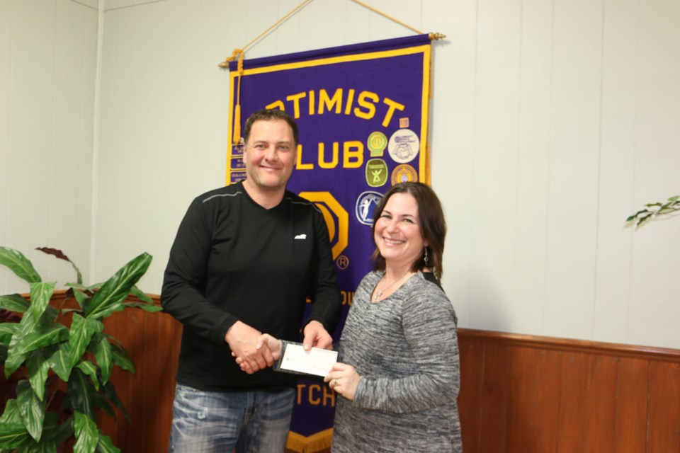 Rod Lees (Optimist member) presents a cheque for $3,300 to Terry-Lee Lees for 183 snowmobile tickets sold by the Arcola Curling Club.