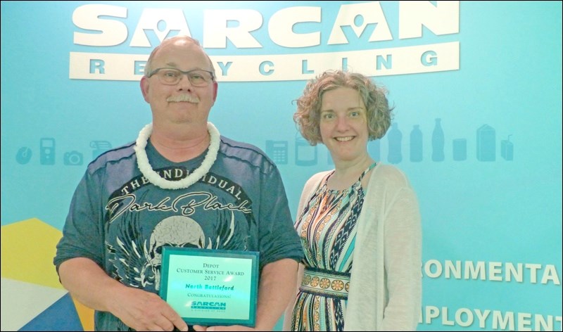 Jeff Bogdan (left), SARCAN depot supervisor for North Battleford, accepts a customer service award from Northwest Regional Manager Chantelle Diakuw.