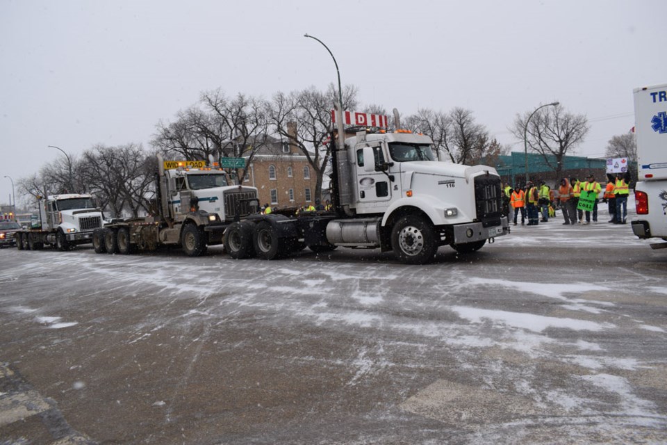 Supporters of the Yellow Vest Movement watch as a truck convoy rolls down Fourth Street.