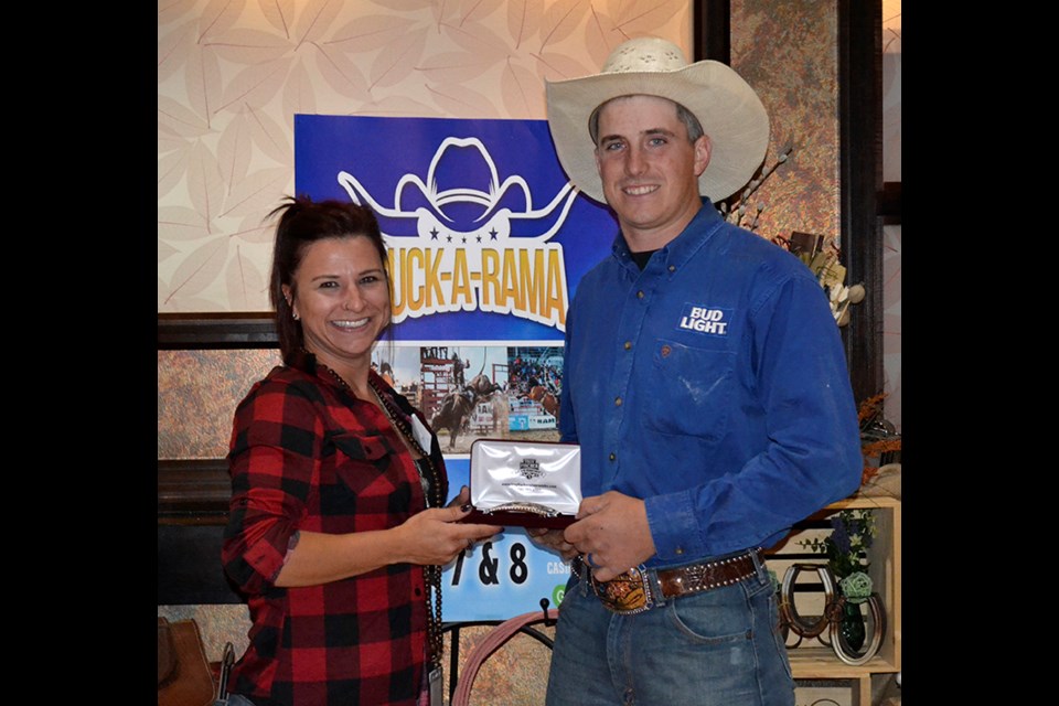 Jennifer Deimuth (left) of the Bear Claw Casino, presents the buckle for Bareback Riding to Brady Bertram at the Bear Claw Casino Buck-a-rama on Aug. 8.