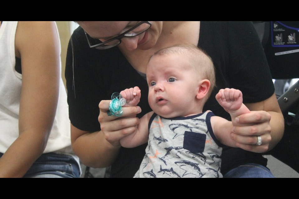 Brecken Reed boogies (with help from his mother) to songs by children’s performer Sylvia Chave at the Tisdale Community Library on Aug. 14. With props and songs Chave captivated the audience of dozens of young community members who came out to enjoy her show. Photo by Jessica R. Durling