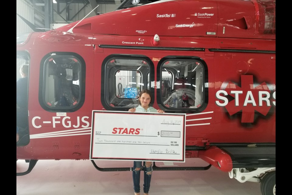 Shaylee Belke holds the cheque with the amount of money she raised for the STARS Air Ambulance. Photo submitted