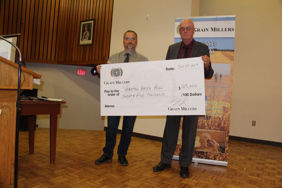 Scott Shiels with Grain Millers presents $25,000 to Vern Brown with the Yorkton Brick Mill Heritage Society.