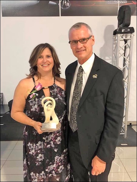 Nancy Schultz receives a Caring Leadership Award from Deputy Minister of Education Rob Currie. Photo