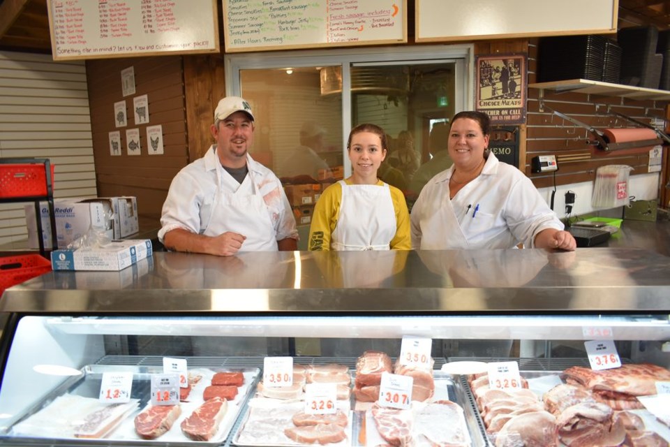 A gleaming, spotless display case holds the meat products at Lorne’s Butcher Block. From left, are: Lorne Woytkiw, Natassia Adams and Jessi Woytkiw.