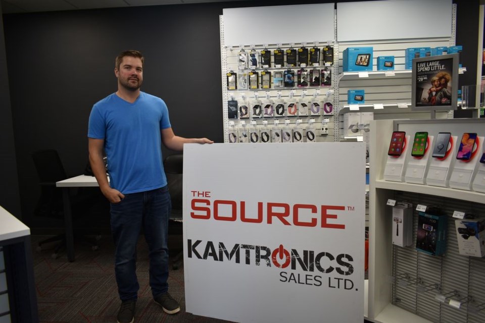 Chris Nykolaishen stood with the new Kamtronics sign that will soon be on display outside the new electronics store in Kamsack.