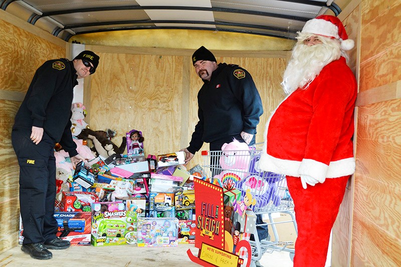 Santa and members of the Carlyle Volunteer Fire Department stacking toys that were collected during the recent Toy Drive.