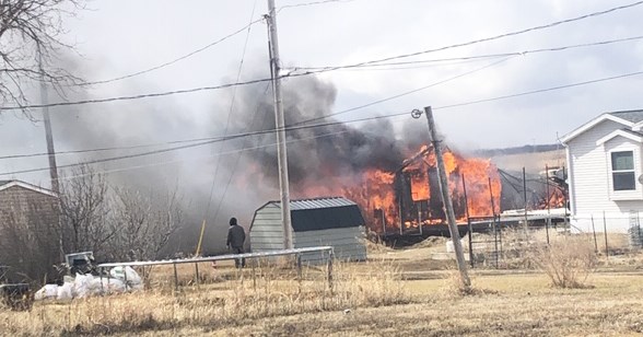 A mobile home in Manor is completely engulfed in flames when a fire started in the garage. Neighbouring homes also suffered damage.