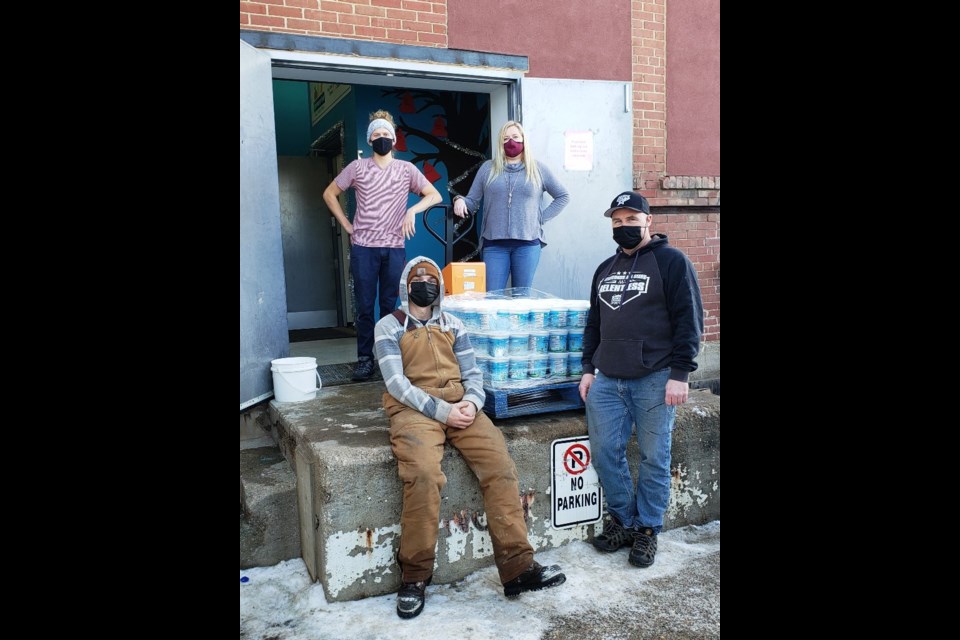 The 鶹Ƶgates deliver 450 containers of honey to Erin Katerynych and Warehouse Coordinator Kjell Graupe at the food bank. Photo submitted