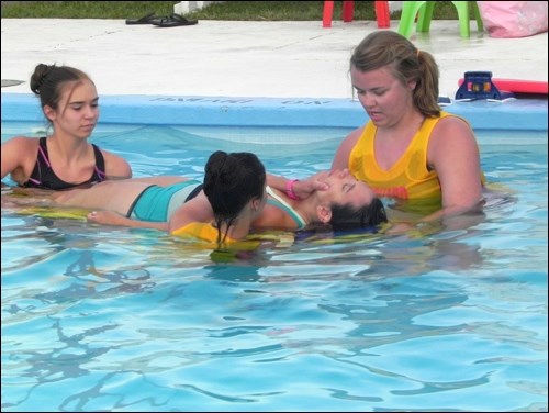 Unity Lifeguards Jessica Weber, Stephanie Schell and Caprice Sherwood surprised swimmers on July 22 when they "rescued" victim Lisa Sherwood. The lifeguards performed a mock spinal rescue, demonstrating to those in attendance what happens when a victim sustains a spinal injury, while head lifeguard Natalie Kiefer reassured watchers it was only a demonstration, at the same time discussing water safety. One of the main causes of spinal injuries while swimming is diving into water that is too shallow. This mock rescue event was held along with a number of other events all week at the Unity swimming pool through July 21-25 to recognize National Drowning Prevention week.