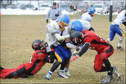 Two of the HCI Mohawks get crunched between members of the Delisle Rebels during their nine-man football provincial final in Delisle on November 13.  HCI came out on top, claiming the provincial title.