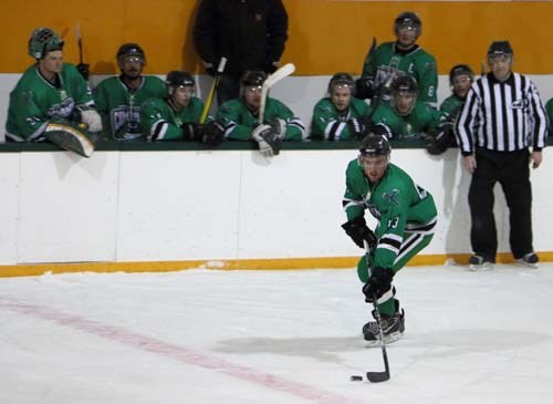 Kevin Morrison takes the puck down the ice with the bench cheering him on.