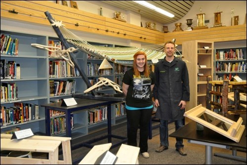 Savannah Martin and her industrial arts instructor Jeff Kardynal in the John Paul II Collegiate library where a variety of shop projects were on display. Savannah built a hammock stand.