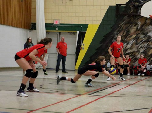 Gracie Schutz (Carlyle), the libero, dives for a ball in tournament action.