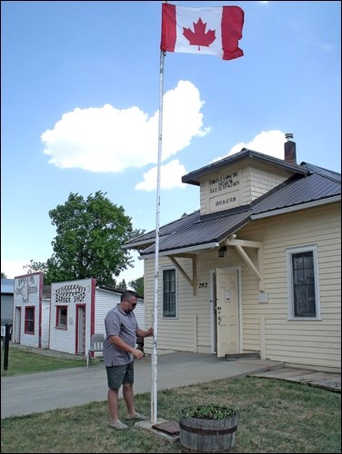 Mayor Tom Redhead raising the flag at the Borden Museum opening.