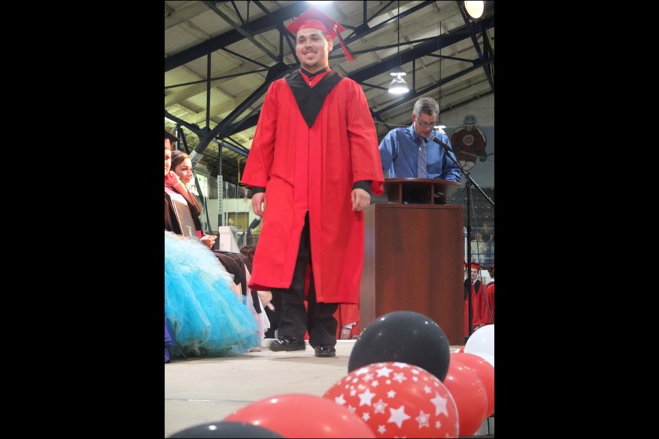 Brandon Oulette walked across the stage to accept his diploma with Hapnot principal Brent Bedford in the background.