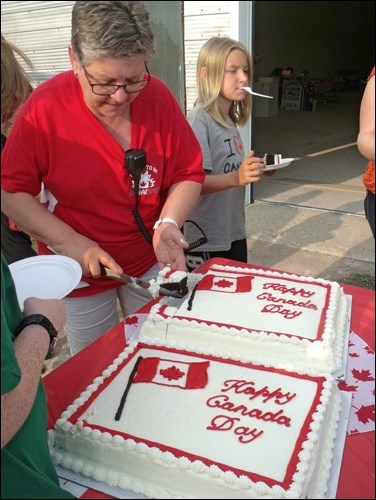 Terri Mitchler cutting the Canada Day cakes to hand out to everyone at the celebration. Photos by Lorraine Olinyk