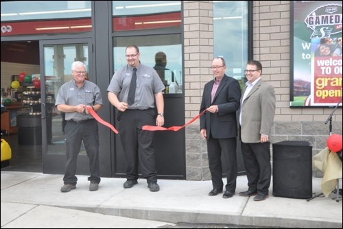 Manager Dave Rogers, site manager Jeff Kitzan, board president Randy Graham, and general manager Mike Nord cut the ribbon at the grand opening of the Discovery Co-op gas bar and convenience store in Battleford. Kitzan also showed off and cut the celebration cake. Also on hand cooking up burgers were volunteers from the Fred Light Museum, with proceeds going to that cause.