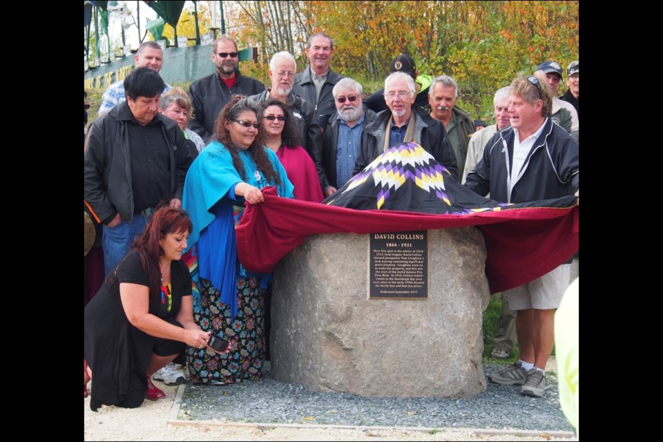 Descendants of David Collins, committee members and onlookers at the unveiling of the cairn. Pictured (front row, left to right) are descendent Kelleen Blouin kneeling with a cup of sugar in honour of a story Collins used to tell, and descendent Margaret Head-Steppan and Mayor Cal Huntley unveiling the cairn; (middle) descendents Tom McNichol and Yvonne Markham, and committee member Gerry Clark; and (back rows) Andre Blouin, descendent Cindy O’Nabigon, Dave Gunn, and the committee’s Buz Trevor, Bill Jackson, Gerard Jennissen, Les Oystryk and Dave Price.