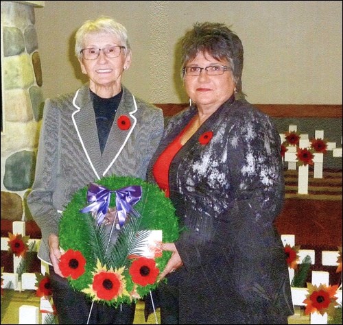 Esther Tkachuk and Christine Gonda lay a wreath representing all mothers.