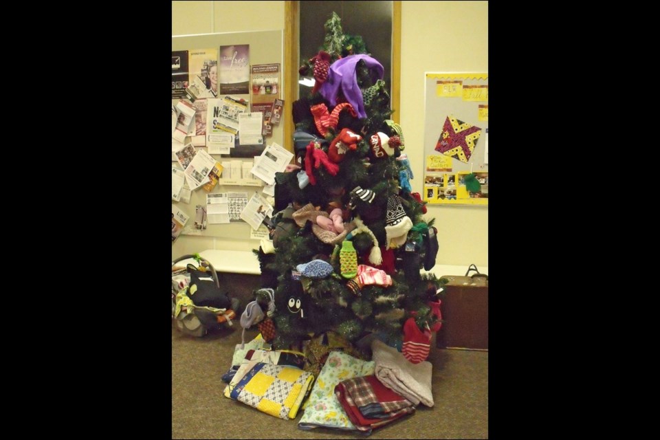 Radisson Lutheran Church tree loaded with knitting with quilts underneath.