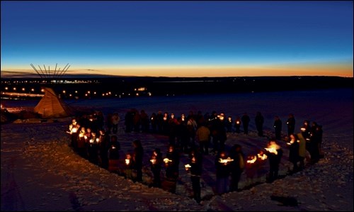 Participants formed a heart holding candles while there was drumming in the background and everyone sang. It was a windy night so it was difficult to keep the candles lit, but their heartfelt message was still movingly conveyed. Photo by Averil Hall