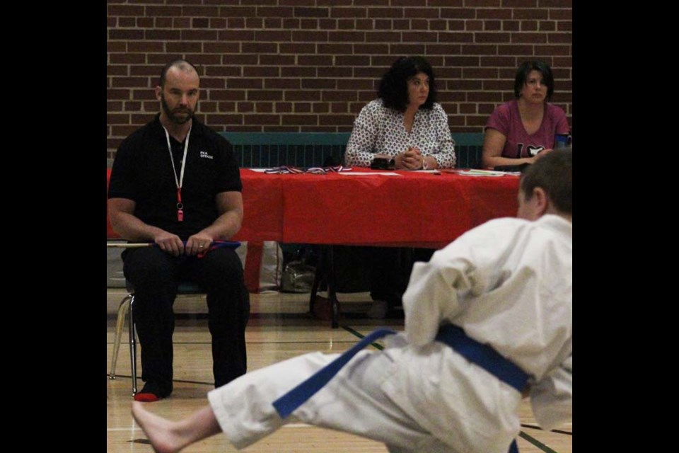 Rurak, in the role of centre official, watches a karate student perform his Kata during the Parkland Karate Association Regional and Invitational tournament.