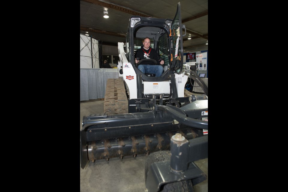 Kelly Stinson of C&C Rentals in Brandon, Manitoba, shows off a new BobCat unit at the indoor displays of the Redvers Oil Showcase. Photo by Brian Zinchuk.