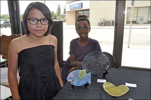 Crissy and Mekdes, Grade 4 students at McKitrick School, were afternoon hostesses at the exhibition of art of the school's after-school art club at the ARC in downtown North Battleford Tuesday of last week. Photos by Jayne Foster