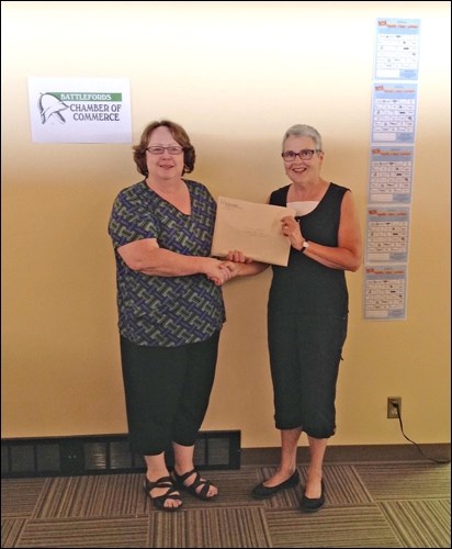 Linda Machniak, executive director of the Battlefords Chamber of Commerce congratulates Name That Logo! first place winner Candace Kopera.