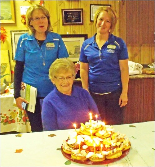 Jackie Meister blows the candles out on the doughnut cake at Borden Seniors’ supper Sept. 28. Standing behind Jackie are Diane Tracksell and Lynette Schmidt of Affinity Credit Union, who brought the doughnuts.