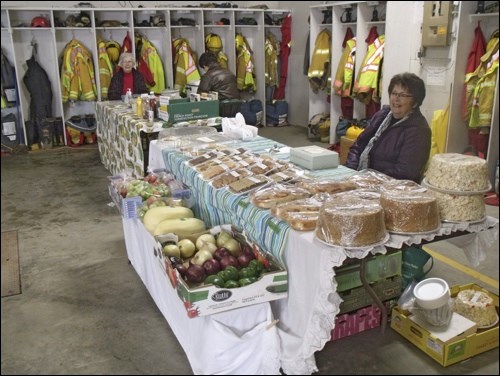 Natalie Gramiak with her table of baking and vegetables and Helen Sutherland and Eleanor Walton at the United Church table selling burgers and hot dogs on the last market day Oct. 7. Photos by Lorraine Olinyk