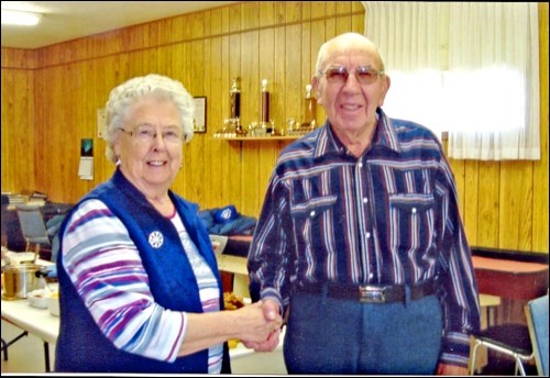 Fay Taylor presents Merrill Miller with an honorary life membership to the Senior Citizens Action Now Club.