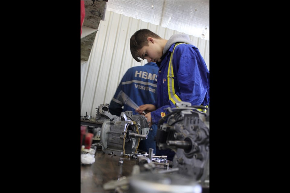 Brady Farkus concentrates on fixing a small motor during a class at the Creighton Community School shop on Wednesday. He is among the students learning in-demand skills through the school’s successful vocational program, based in the Sportex.