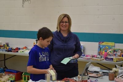 Trying to pick out gifts at the Recycled Christmas Exchange at Canora Junior Elementary School were Cooper Kraynick and Tracey Bletsky.