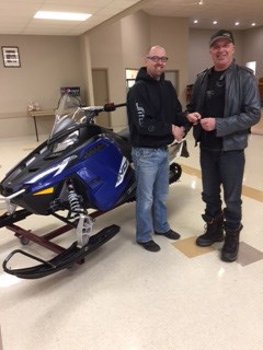 Bart Hartl, left, president of the Kelvington Trailblazers Snowmobile Club, presented Dale Romanus with the 2017 Polaris Indy snowmobile. The snowmobile was the raffle prize for the winter spirit snowmobile rally.