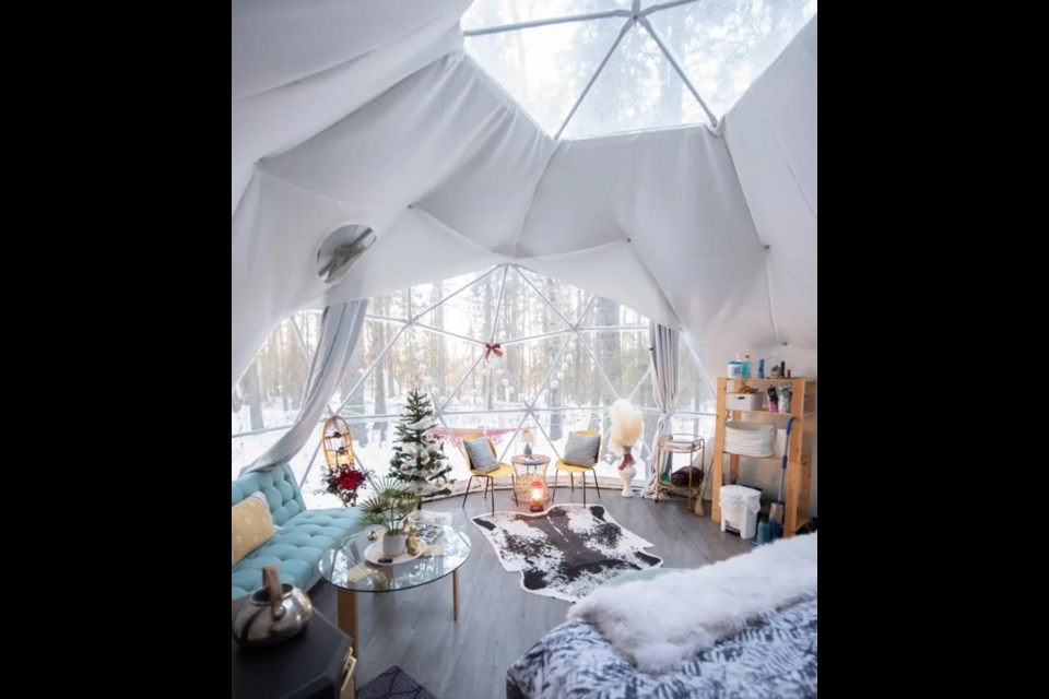 The interior of a beautifully decorated glamping geodome at Glamp Good in Alberta with winter views out the window.  / Glamp Good | Facebook