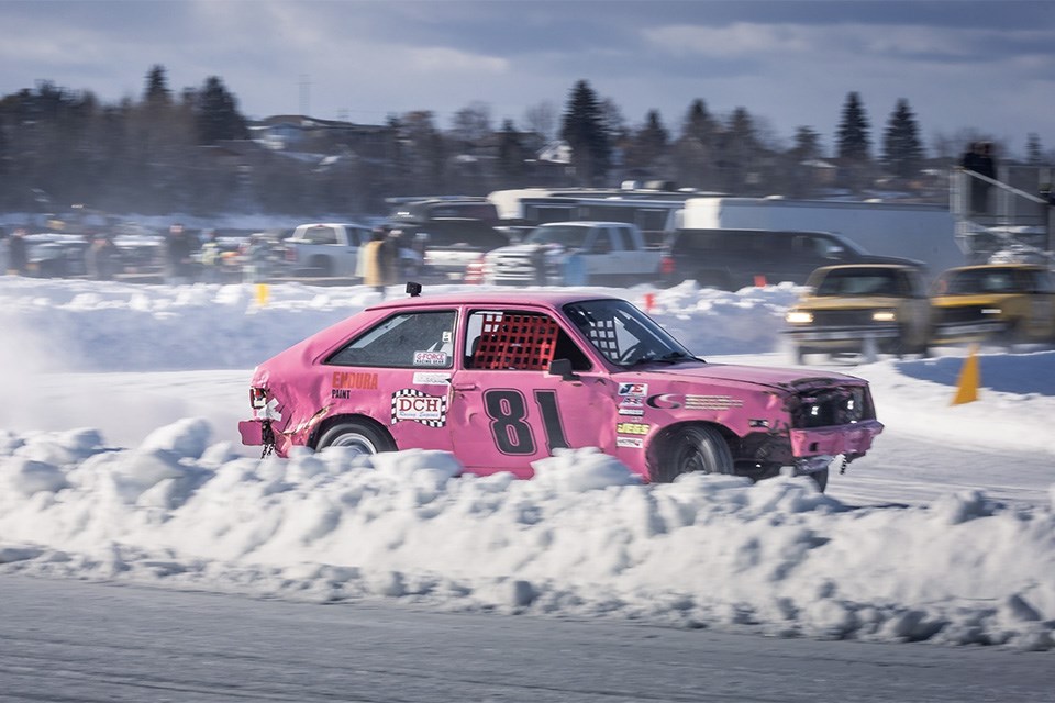 A hot pink racing car speeds along a frozen racetrack on top of Lac La Biche. The Lac La Biche ICE Festival of Speed | Facebook