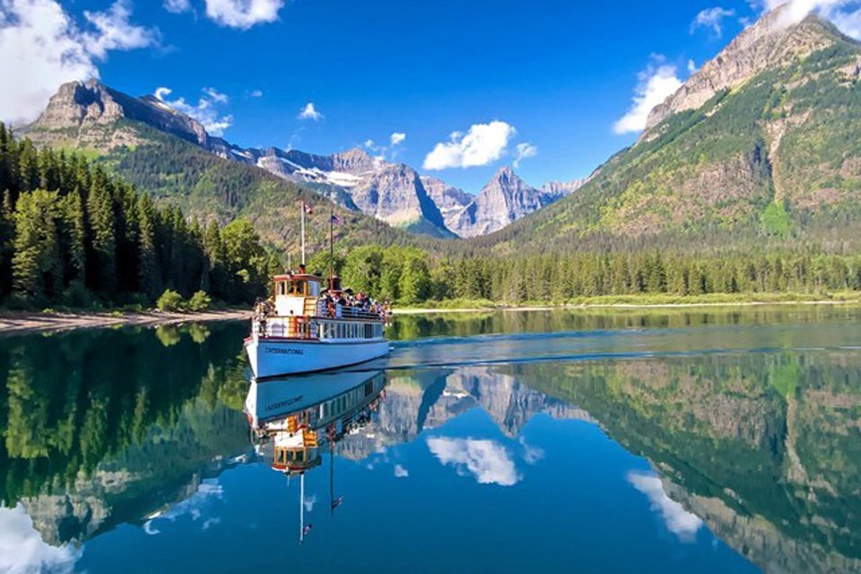 View of Waterton Lake with a Ferry Boat and a beautiful mountain backdrop / Travel Alberta