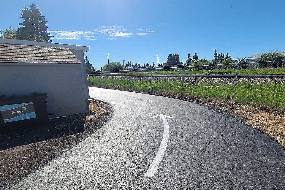 A road with a white arrow pointing around the corner towards The Boxcar Grill in Eckville, Alberta. / The Boxcar Grill | Facebook